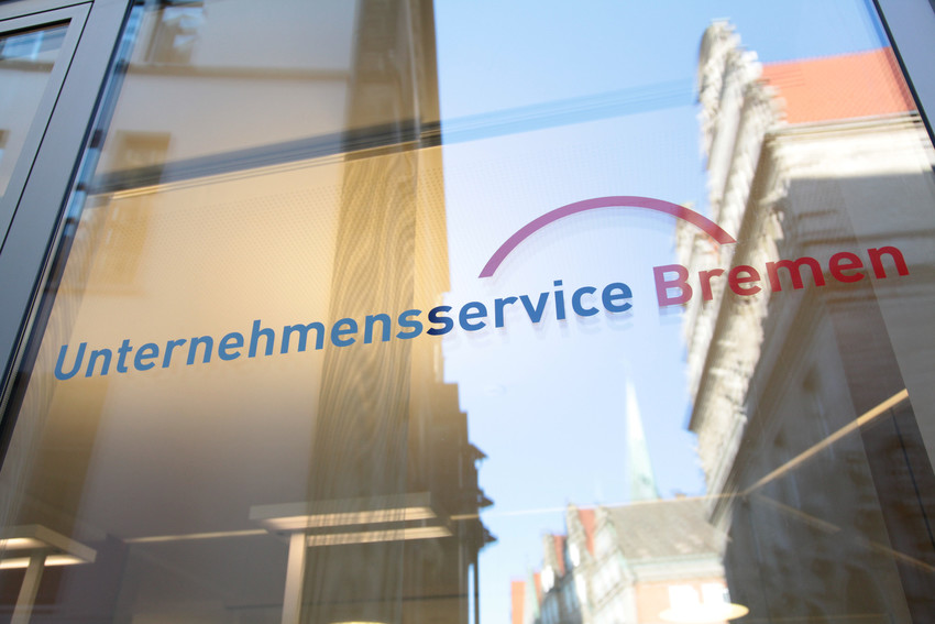 Das Logo vom Unternehmensservice-Bremen auf einer Glasscheibe